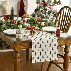 a dining room table set for christmas with plates and napkins on the placemat