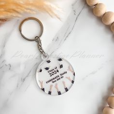 a keychain with the words class of 2012 printed on it next to beads