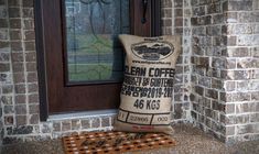 a bag of coffee sitting on top of a door mat in front of a brick building