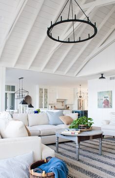 a living room filled with furniture and a chandelier hanging over the top of it