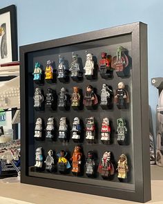 a shadow box with lego minifigures in it on a table next to other toys