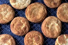 several round cookies sitting on top of a cooling rack next to each other in front of a blue background