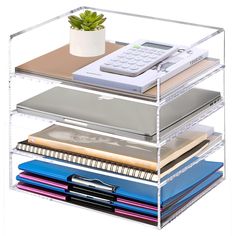 three tiered clear shelf holding various types of books, notebooks and a calculator