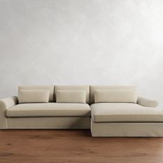 a couch sitting on top of a wooden floor next to a white wall and wood floors