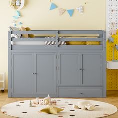 a gray bunk bed sitting on top of a wooden floor next to a white rug