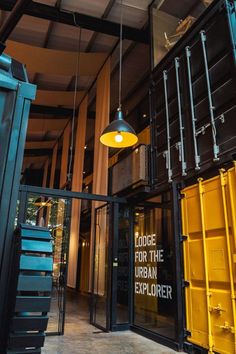 the entrance to an office building with yellow shipping containers and a light hanging from the ceiling