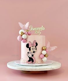 a minnie mouse birthday cake with pink and gold decorations