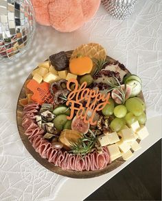 a platter filled with fruit and cheese on top of a table