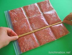 a person holding a chopstick in front of some food wrapped in cellophane