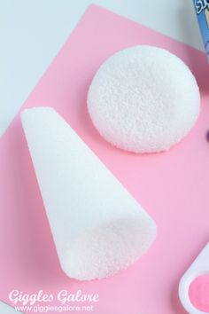 two white sponges sitting on top of a pink surface