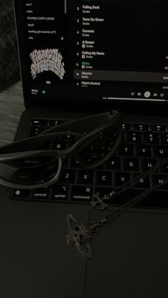 a laptop computer sitting on top of a table next to a pair of black glasses