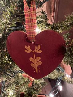 a heart shaped ornament hanging from a christmas tree