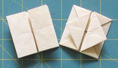 two origami pieces sitting on top of a cutting board