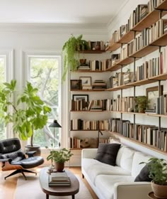 a living room filled with furniture and bookshelves full of books next to a window