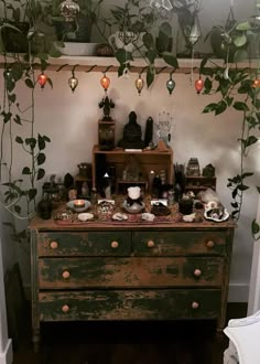 an old dresser with lots of items on top of it and hanging from the ceiling