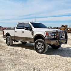 a white truck parked on top of a dirt field