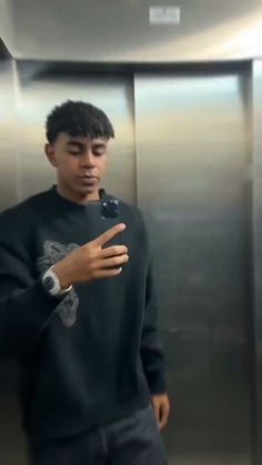 a young man standing in front of an elevator