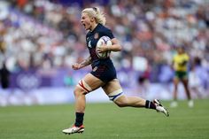 a female rugby player running with the ball