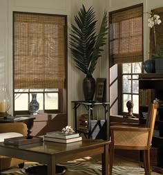 a living room filled with furniture and windows covered in bamboo blindes next to a coffee table