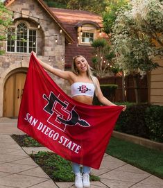 a beautiful young woman holding a san diego state flag