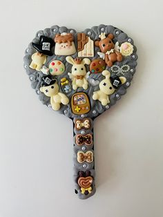 a close up of a key shaped like a heart with many different animals on it