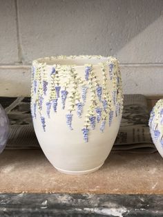 three white vases with blue flowers on them