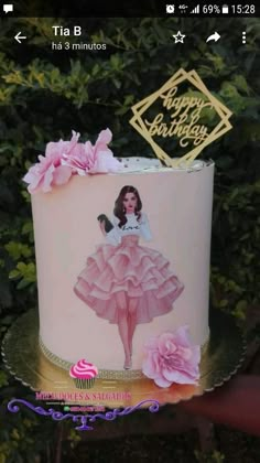 a birthday cake decorated with pink flowers and a woman's image on the frosting