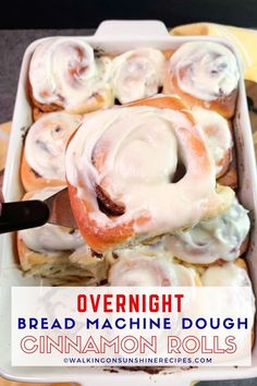 a tray filled with cinnamon rolls covered in icing and sitting on top of a table