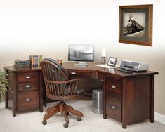 an office desk with two computers on it and a chair in front of the desk