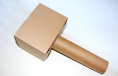 an open cardboard box sitting on top of a white table next to a brown paper roller