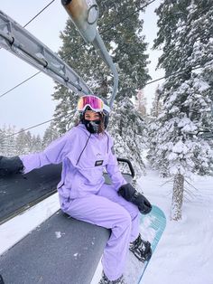 a person sitting on a ski lift in the snow