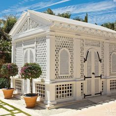 a white house with potted plants in front of it