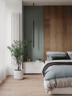 a bedroom with wood paneling and white bedding in the corner, along with two planters on either side of the bed