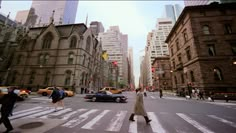 people are crossing the street at an intersection in new york city, with tall buildings on either side