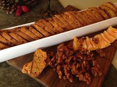 some food is laying out on a cutting board next to bread and other foodstuffs