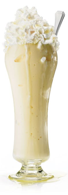 an ice cream sundae with whipped cream and toppings in a tall glass cup