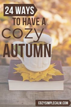 a cup of coffee sitting on top of a book with the title 24 ways to have a cozy autumn