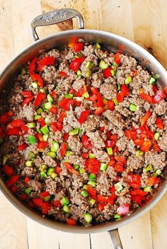 a pan filled with meat and vegetables on top of a wooden table