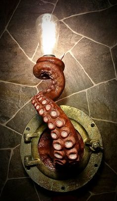 an octopus is hanging from a hook on a stone wall in the shape of a lamp