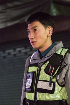 a young man in a police uniform standing next to a building