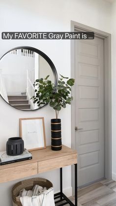 a mirror sitting on top of a wooden table next to a potted plant in front of a door