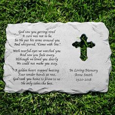 a memorial stone with a cross and poem on it in the middle of some grass