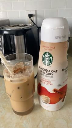 there is a cup of coffee next to a blender and an iced drink on the counter