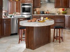 a large kitchen with wooden cabinets and marble counter tops, along with stainless steel appliances