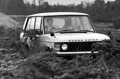 an old car is parked in the middle of a field with flowers on its hood