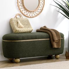 a green bench sitting next to a mirror and potted plant