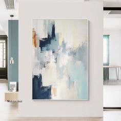 an abstract painting hangs on the wall next to a dining room table