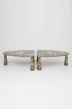 two marble coffee tables sitting side by side in front of a white wall and floor