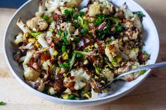 a white bowl filled with food on top of a wooden table