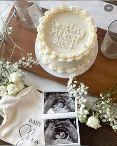 a baby shower cake on a table next to flowers and other personalized items for the baby